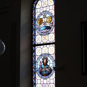 Warth, Pfarrkirche Hl. Sebastian, Glaubensbekenntnis,  Sonne, Mond und Sterne, Gott mit Segnungsgeste Heiliger Geist als Taube, Schrift: Und an Jesus Christus seinen eingeborenen Sohn unseren Herrn, 1895, Tiroler Glasmalerei